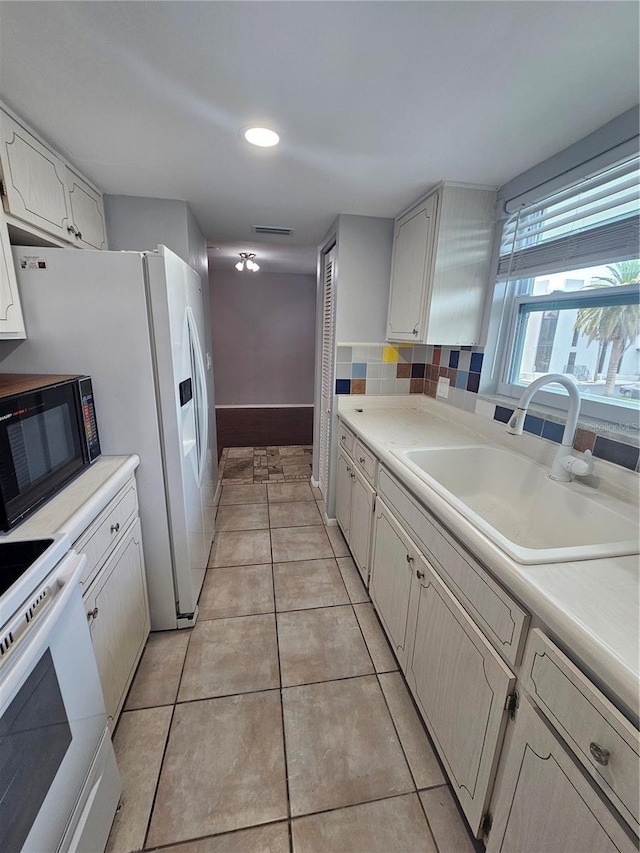1433 S Belcher Rd Unit A12, Clearwater, FL 33764 - kitchen with white appliances, a sink, light countertops, tasteful backsplash, and recessed lighting