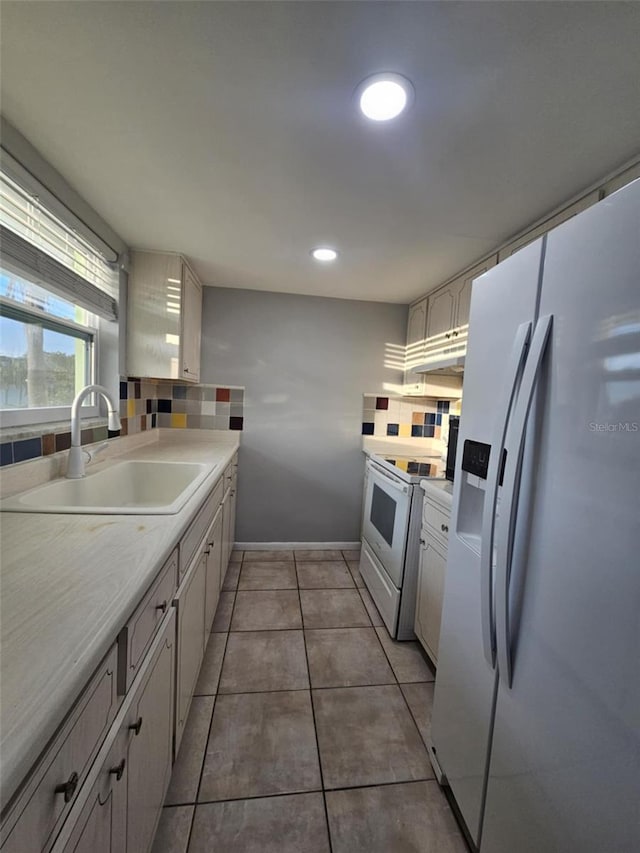 1433 S Belcher Rd Unit A12, Clearwater, FL 33764 - kitchen with fridge with ice dispenser, a sink, white range with electric stovetop, light countertops, and baseboards