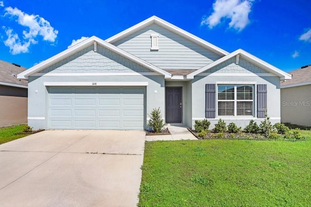 view of front of home featuring a front yard, concrete driveway, an attached garage, and stucco siding