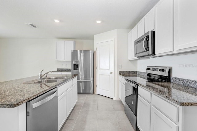 kitchen featuring light tile patterned floors, recessed lighting, a sink, white cabinets, and appliances with stainless steel finishes