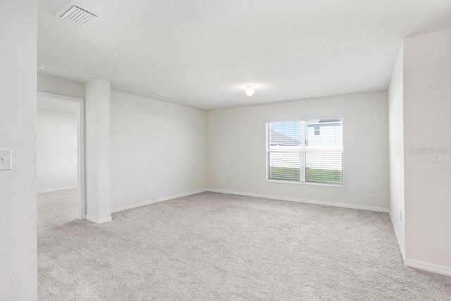 carpeted empty room featuring visible vents and baseboards