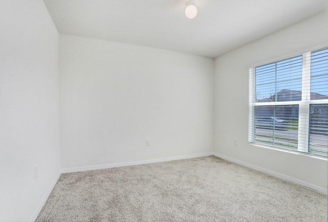 unfurnished room with carpet floors and baseboards