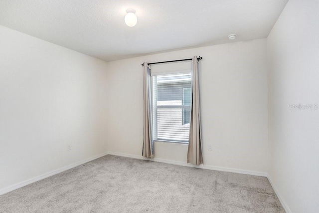 carpeted spare room with baseboards