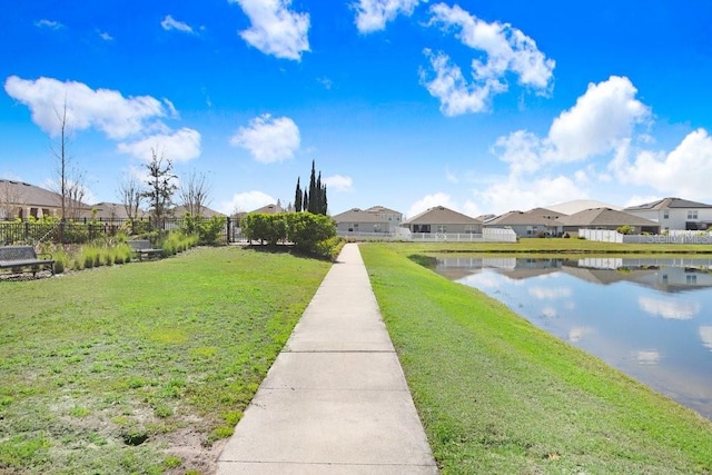 surrounding community with a residential view, a water view, a lawn, and fence