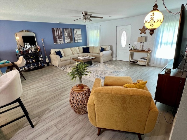 living room featuring a wealth of natural light, light wood-style flooring, and a ceiling fan