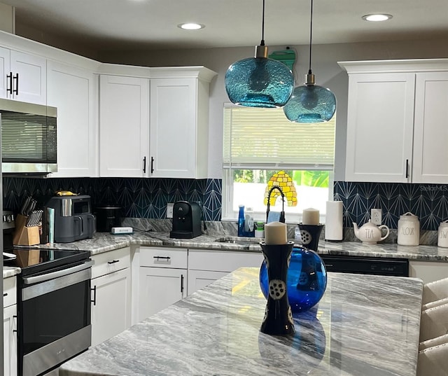 kitchen featuring backsplash, appliances with stainless steel finishes, and white cabinets