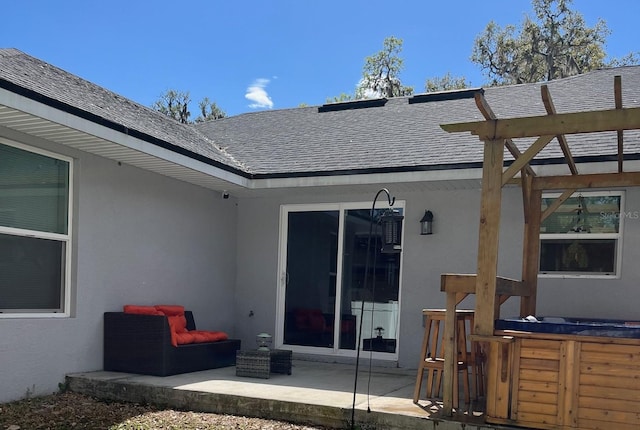 exterior space featuring stucco siding, a patio, and roof with shingles