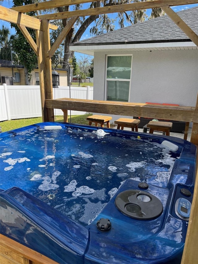 view of pool featuring fence and a hot tub