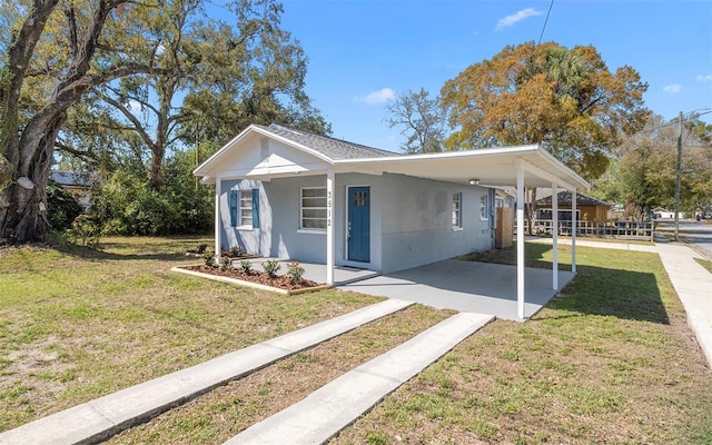 view of property exterior with an attached carport, a lawn, and stucco siding