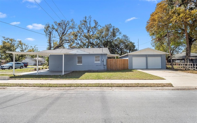 view of front of property with a detached garage, fence, an outdoor structure, and a front yard