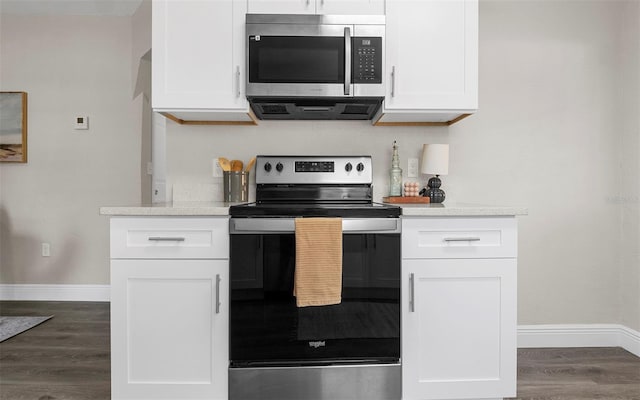 kitchen with white cabinetry, appliances with stainless steel finishes, light countertops, and dark wood-style flooring