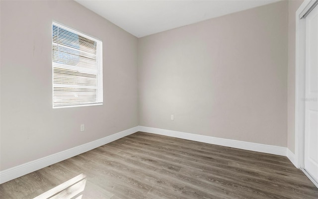 spare room featuring wood finished floors and baseboards