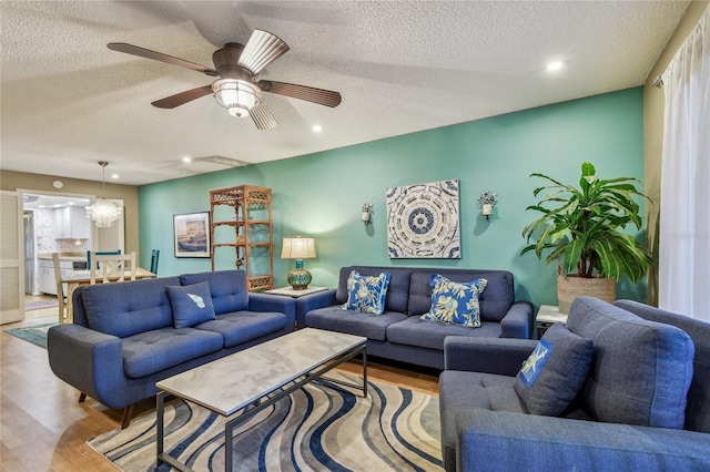 living room featuring recessed lighting, a textured ceiling, ceiling fan, and wood finished floors