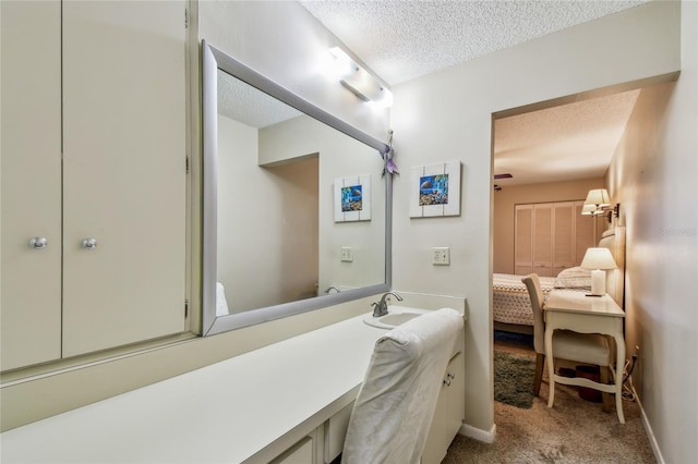 bathroom with vanity, baseboards, and a textured ceiling