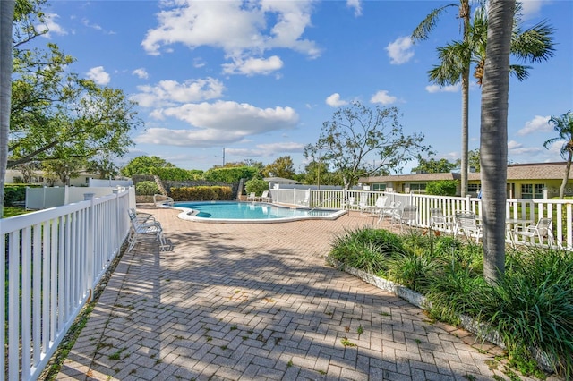 pool with a fenced backyard and a patio area