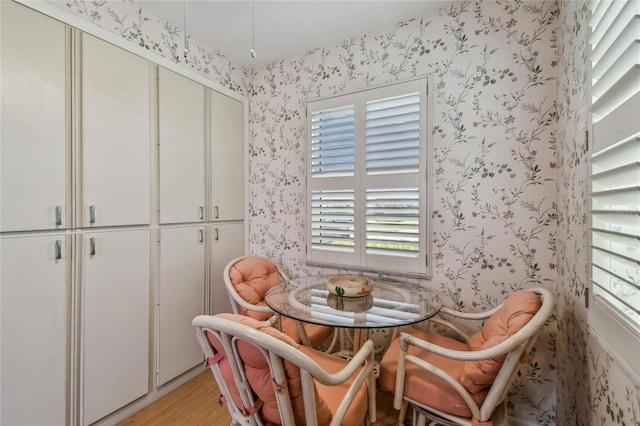 dining area with light wood-style flooring and wallpapered walls