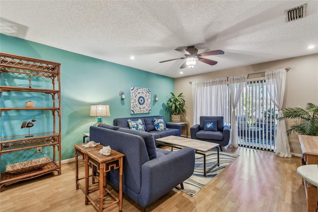 living area with visible vents, baseboards, recessed lighting, wood finished floors, and a ceiling fan