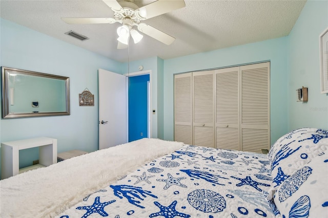 bedroom with visible vents, a textured ceiling, a closet, and ceiling fan