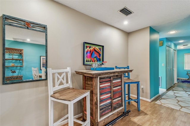 bar featuring recessed lighting, visible vents, baseboards, and wood finished floors