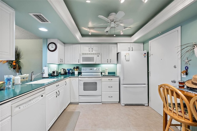 kitchen featuring white appliances, light tile patterned floors, visible vents, a tray ceiling, and a sink