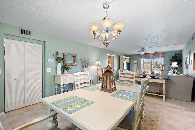 dining room with a textured ceiling, ceiling fan with notable chandelier, light tile patterned flooring, and visible vents