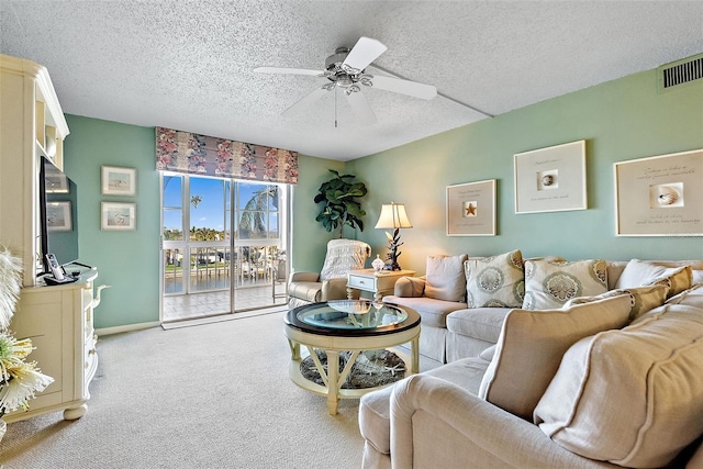 living room with light colored carpet, visible vents, a ceiling fan, a textured ceiling, and baseboards