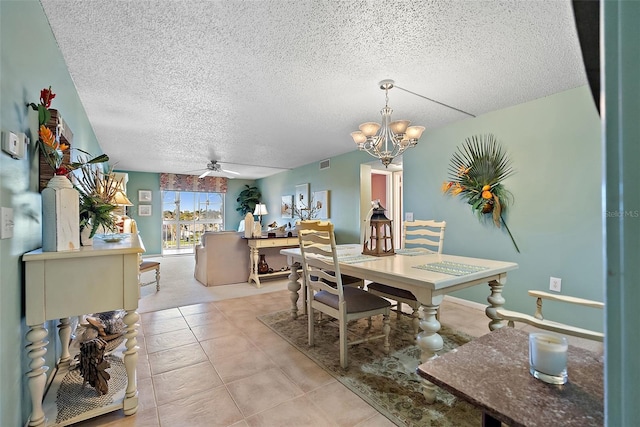 dining space with light tile patterned floors, visible vents, a textured ceiling, and ceiling fan with notable chandelier