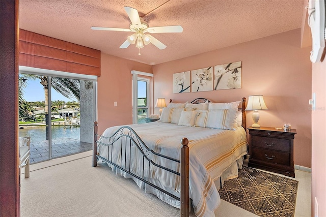 bedroom featuring carpet floors, access to outside, ceiling fan, and a textured ceiling