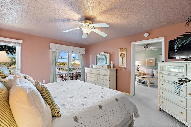 bedroom with a ceiling fan, carpet flooring, and a textured ceiling