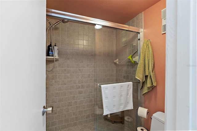 bathroom with a shower stall and toilet