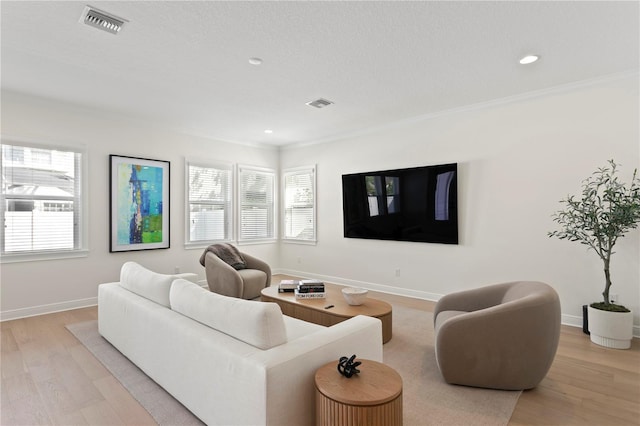 living area with a healthy amount of sunlight, light wood-style flooring, and baseboards