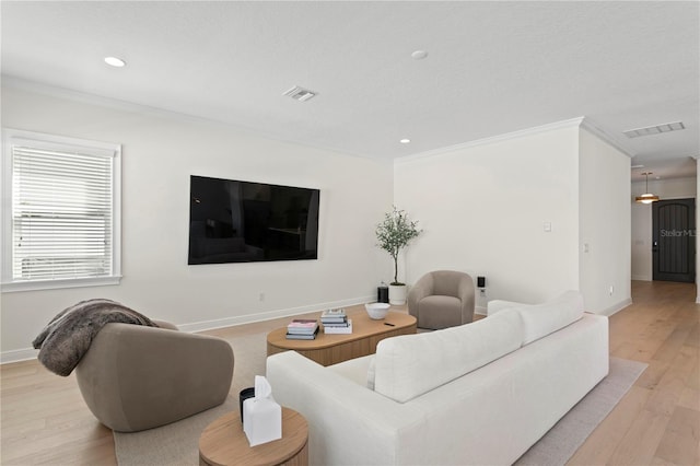 living area with light wood-style flooring, visible vents, and baseboards