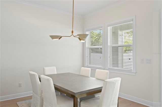 dining space with light wood finished floors, baseboards, and crown molding