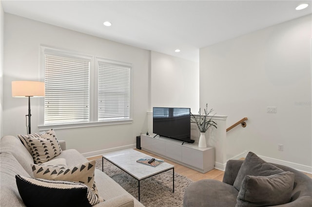 living area with baseboards, light wood-type flooring, and recessed lighting