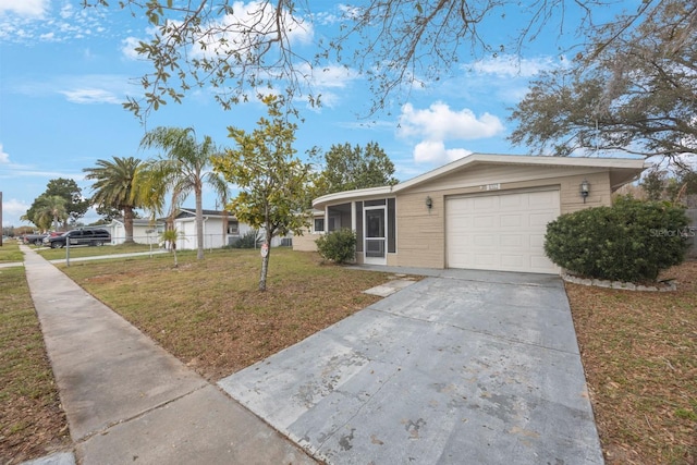 view of front facade featuring a sunroom, concrete driveway, an attached garage, and a front lawn