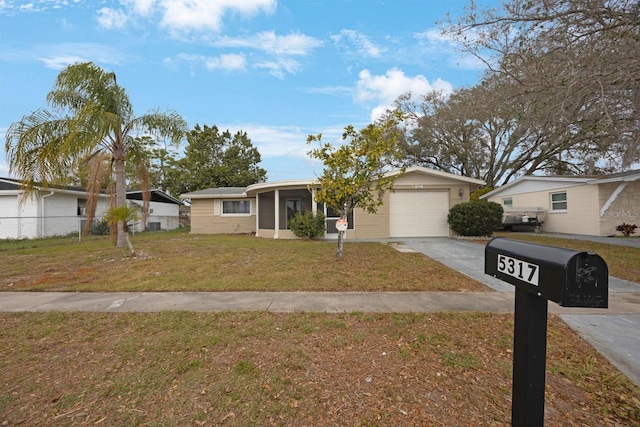 view of front of home featuring aphalt driveway, a front yard, fence, and a garage