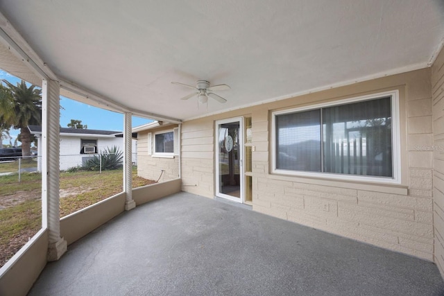 unfurnished sunroom featuring a ceiling fan