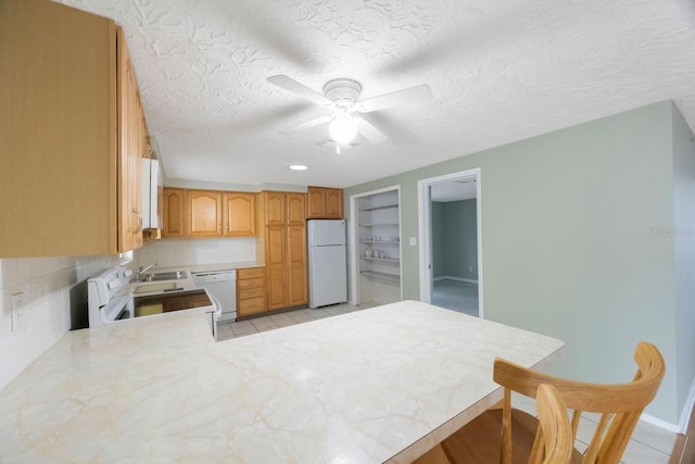 kitchen featuring light countertops, light tile patterned flooring, ceiling fan, a textured ceiling, and white appliances