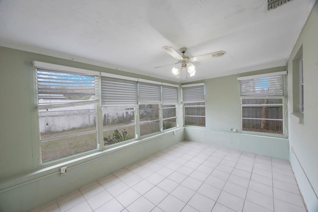 unfurnished sunroom with visible vents and a ceiling fan