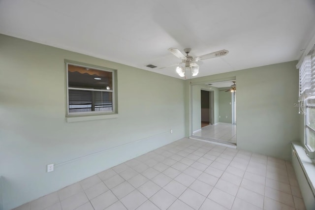 spare room featuring light tile patterned floors, ceiling fan, and visible vents