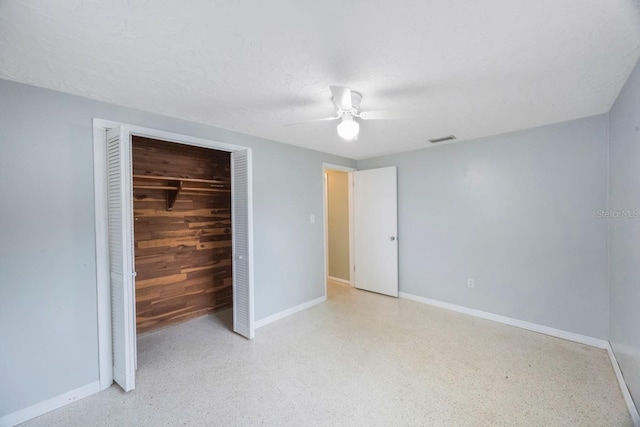 unfurnished bedroom with light speckled floor, a closet, visible vents, and baseboards