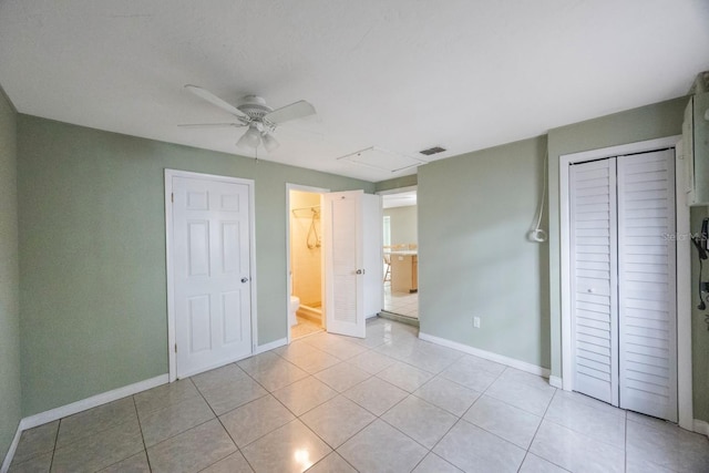 unfurnished bedroom featuring light tile patterned floors, a closet, visible vents, and baseboards