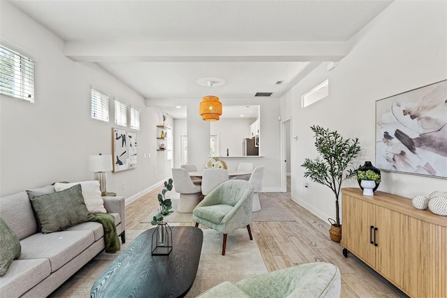 living room featuring beam ceiling, light wood-style flooring, and baseboards