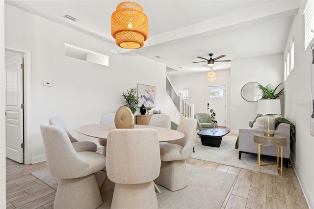 dining area with wood tiled floor, visible vents, stairway, and baseboards