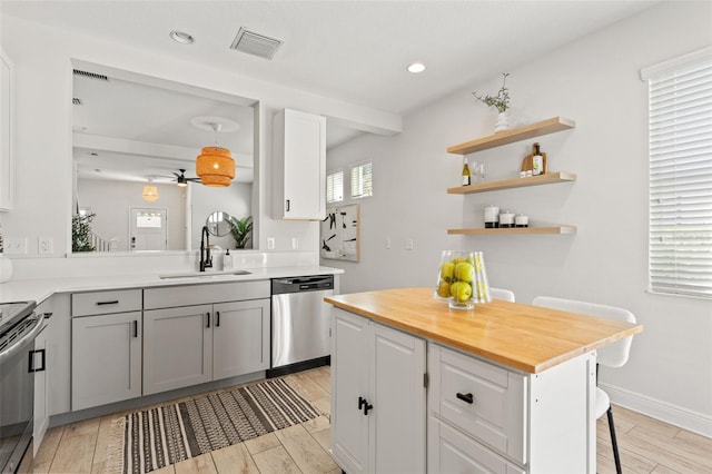 kitchen featuring stainless steel appliances, a breakfast bar, a kitchen island, a sink, and visible vents