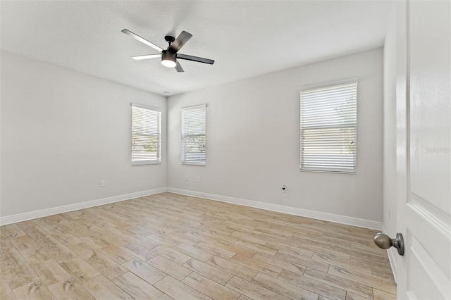 unfurnished room with light wood-type flooring, baseboards, and a ceiling fan