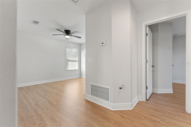 spare room with baseboards, visible vents, ceiling fan, and light wood finished floors