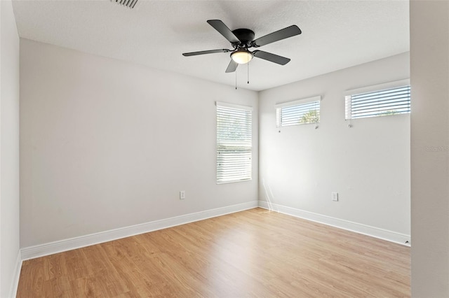 unfurnished room featuring light wood finished floors, ceiling fan, and baseboards