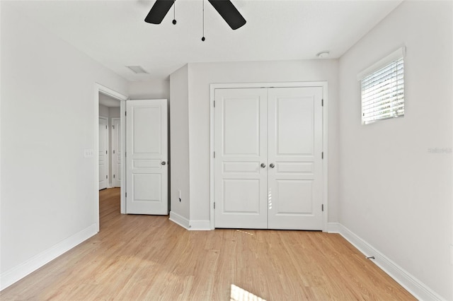 unfurnished bedroom featuring light wood finished floors, visible vents, baseboards, ceiling fan, and a closet