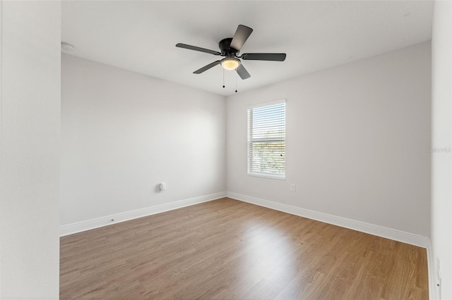 empty room with ceiling fan, light wood-style flooring, and baseboards